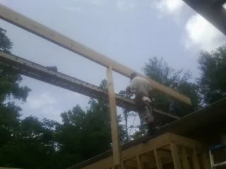 Carpenter setting a ridge beam over a new addition frame — Ice Dam Removal by Roofing Brothers in Starlight