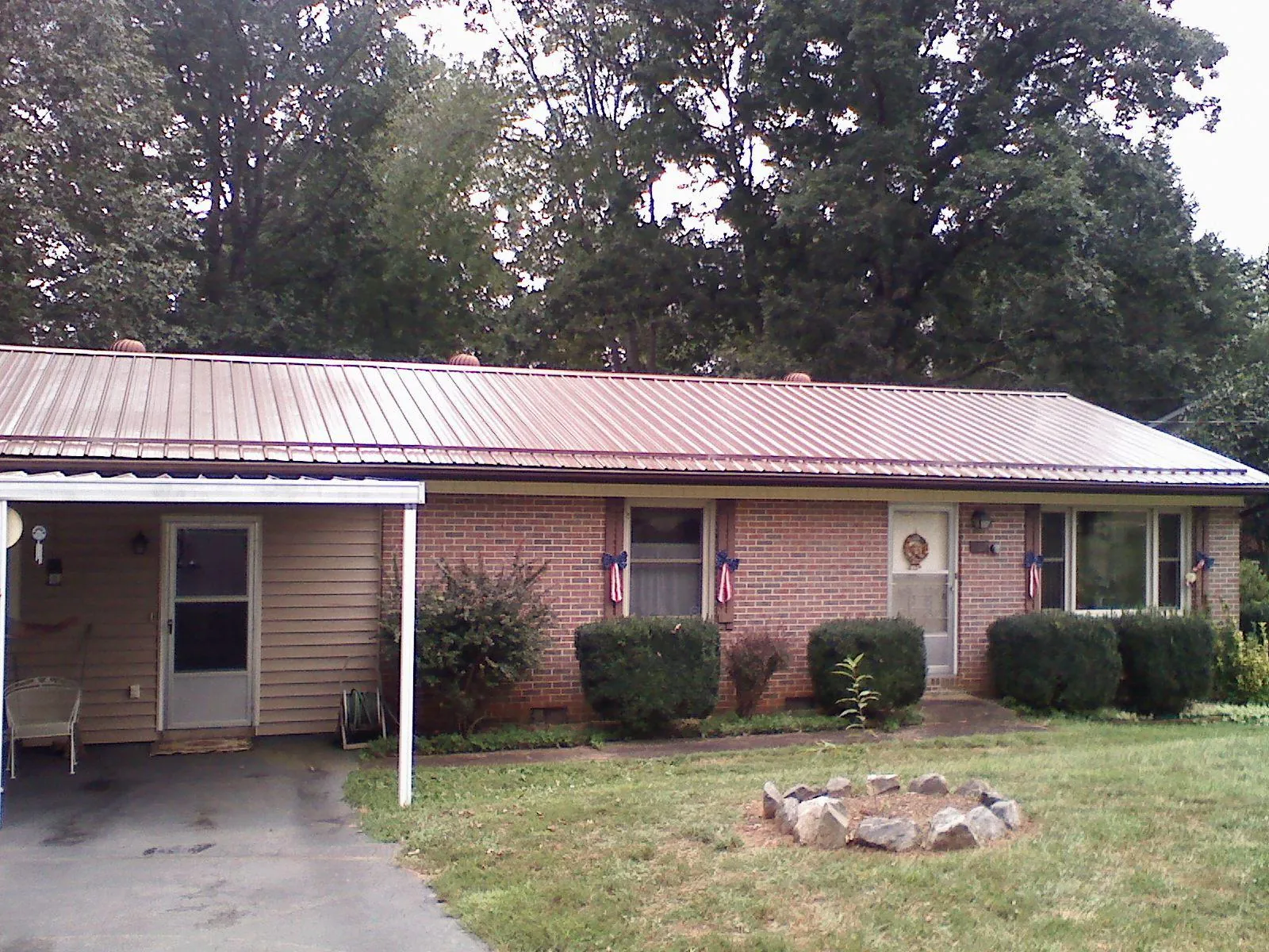 Bronze metal roof and carport on a brick ranch home — Roof Repair work by our crew in Starlight
